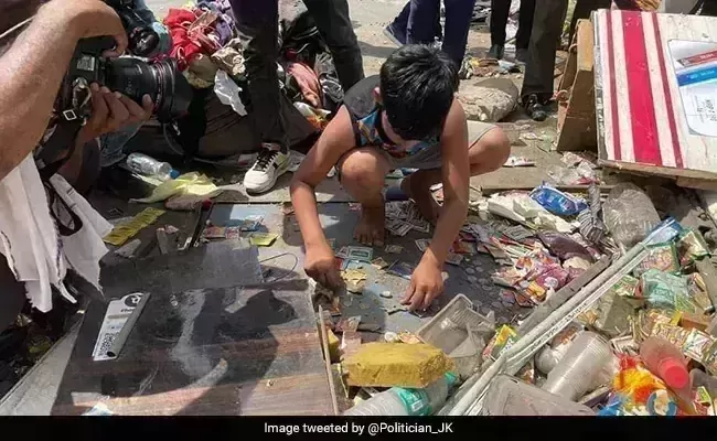 In Delhis Jahangirpuri, a boy collects coins from the fathers destroyed shop