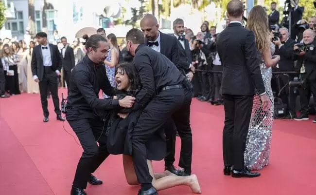 Topless woman storms Cannes red carpet to protest against sexual violence in Ukraine