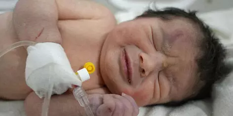 Baby born under rubble of her home in Syria rushed to hospital