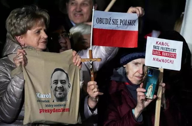 Supporters of presidential candidate Karol Nawrocki hold up signs as they rally in Warsaw, May 13, 2025. (AP Photo)