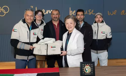 Members of the UAE Alpine Ski Team present their official training suit to an Olympic Museum representative during a ceremony at the Milano Cortina 2026 Winter Games.
