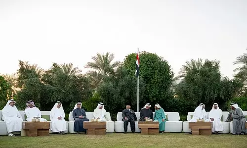 UAE President Sheikh Mohamed bin Zayed and the Rulers of the emirates gather outdoors for an iftar meeting in Abu Dhabi, with the UAE flag in the background.