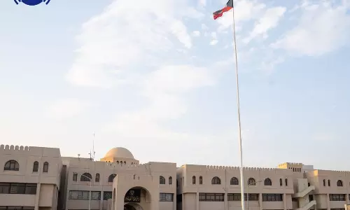 Exterior view of Amir Hospital in Kuwait with the national flag flying in front of the building