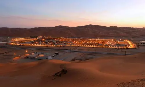Shaybah Oil Field illuminated at dusk in the Empty Quarter desert of Saudi Arabia.