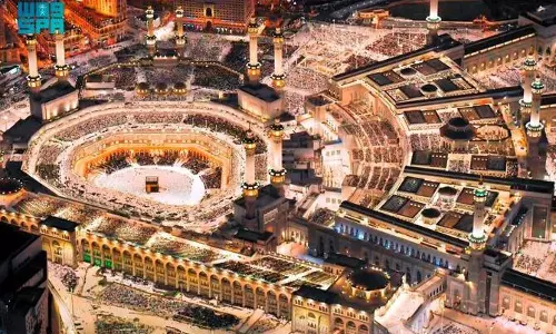 Aerial night view of the Grand Mosque in Makkah filled with worshippers surrounding the Kaaba during Ramadan prayers.