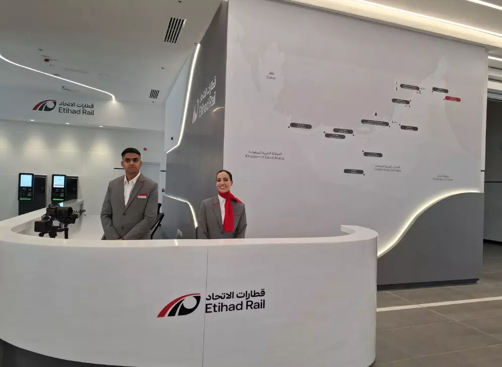 Staff members stand at the reception area inside Etihad Rail’s Fujairah Passenger Station, with a route map of the UAE rail network displayed on the wall behind them. Staff members stand at the reception area inside Etihad Rail’s Fujairah Passenger Station, with a route map of the UAE rail network displayed on the wall behind them.