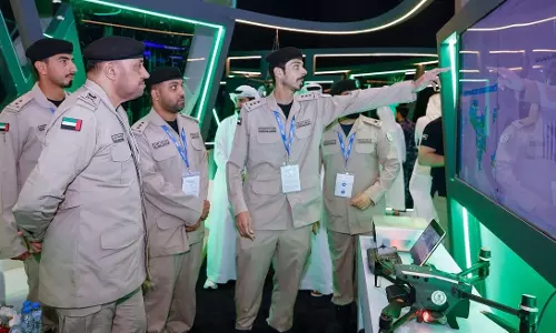 Sharjah Police officers demonstrate AI-powered security and drone technologies at an exhibition stand during ISNR Abu Dhabi 2026.